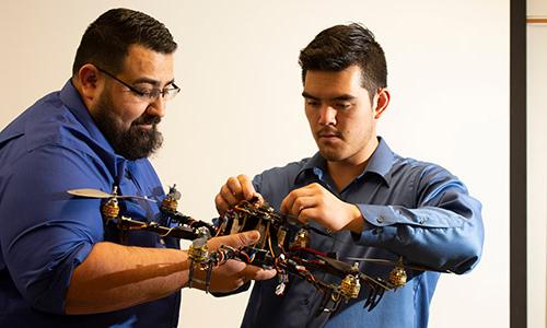 2 electrical engineers working on circuitry of a drone